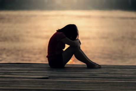 Smutná a sklamaná žena na moli pri mori plače